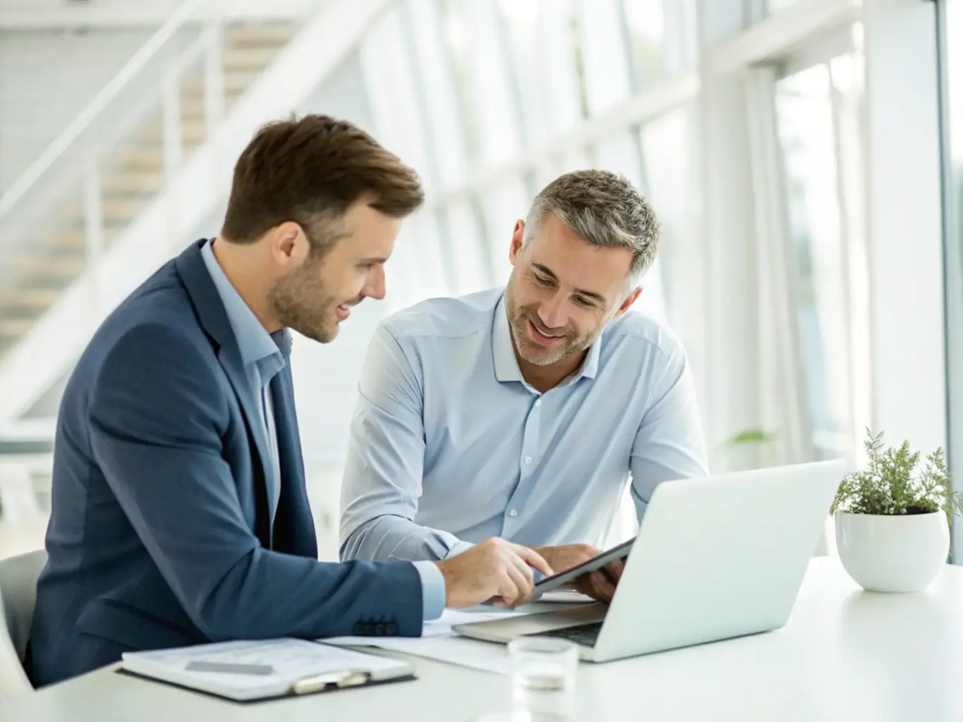A consultant discussing financial charts and plans with a business owner in a modern office, illustrating AHA Accountancy's financial advisory services.